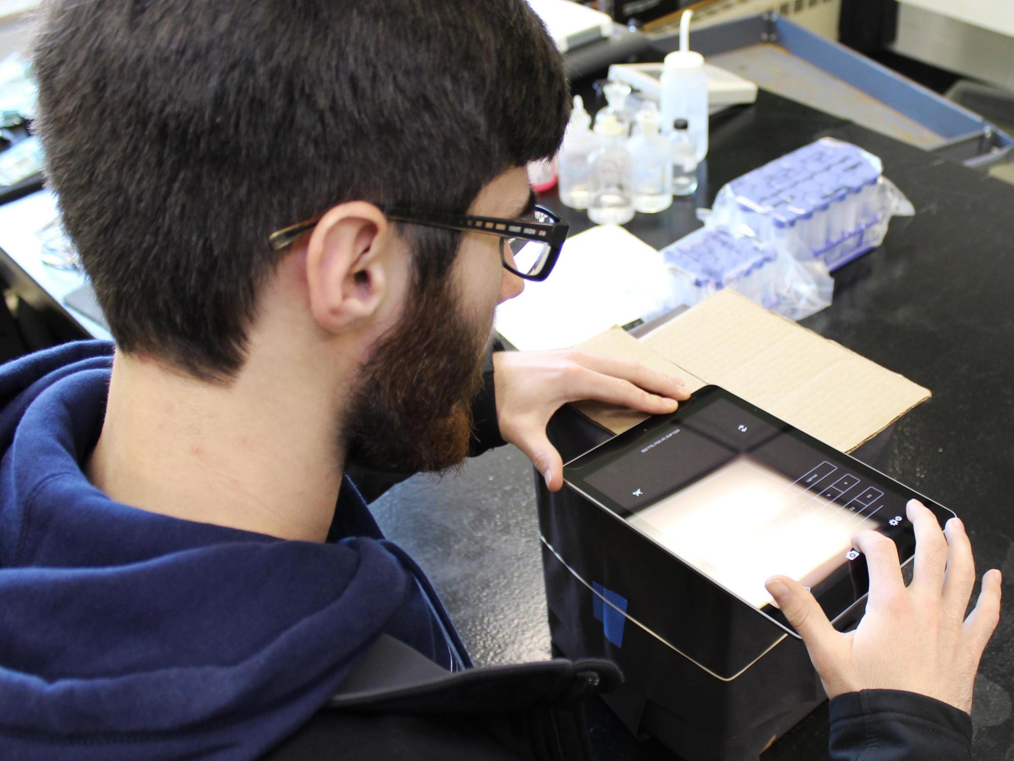 Student placing iPad on box to take photo