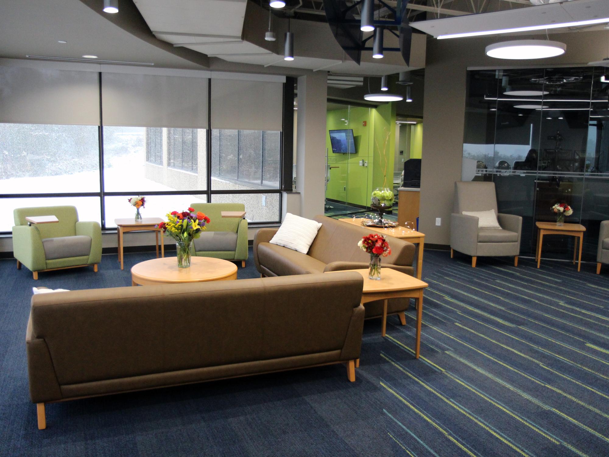 Knowledge Commons lounge space with tables, chairs, and sofas