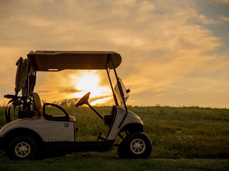 Sunrise behind golf cart on golf course