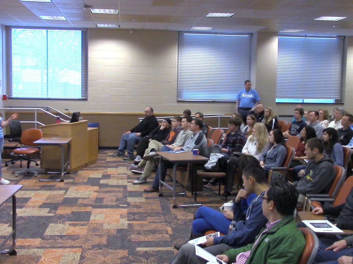 student presenting to crowded lecture hall
