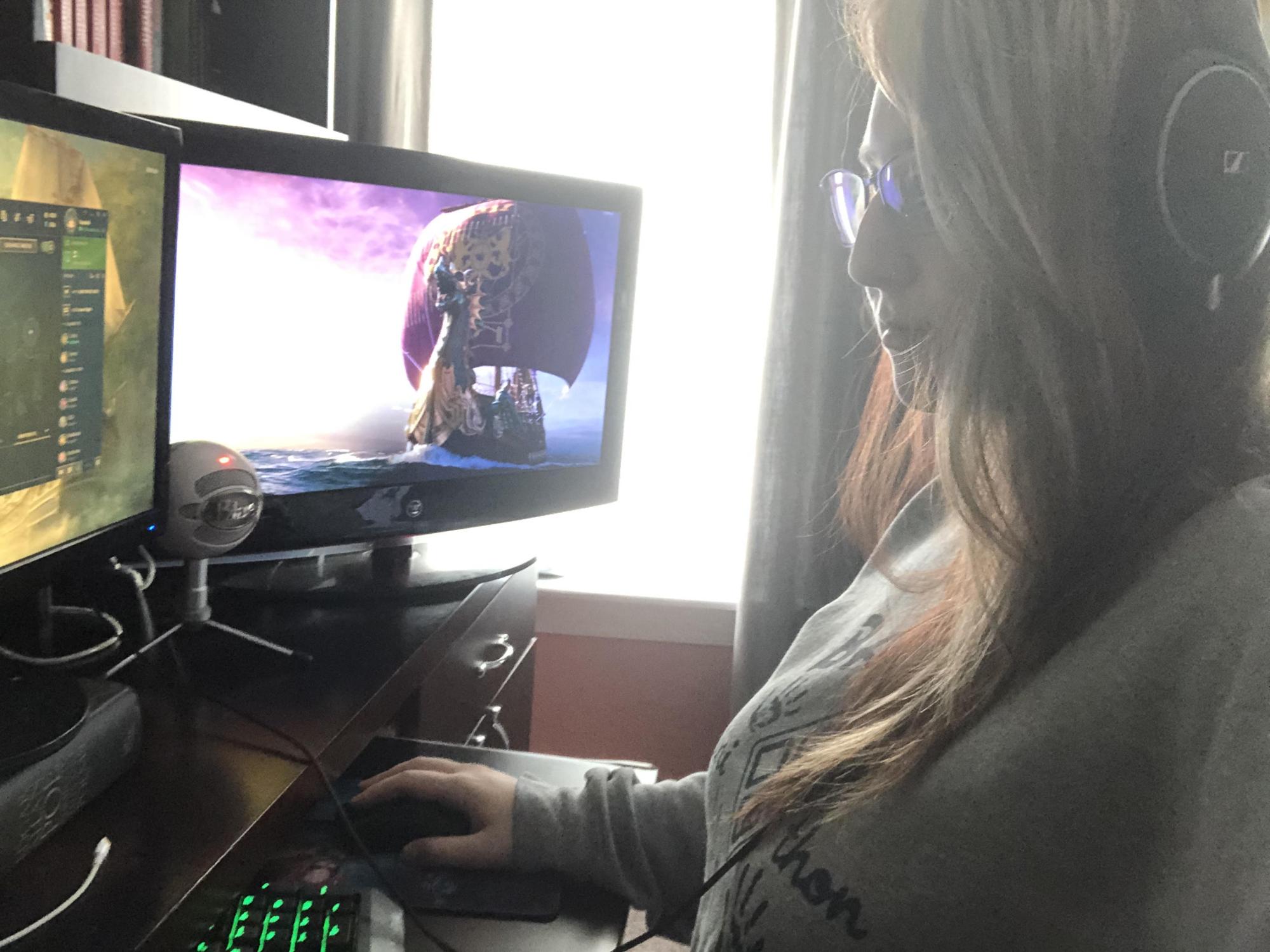 student looking at computer screen featuring video game