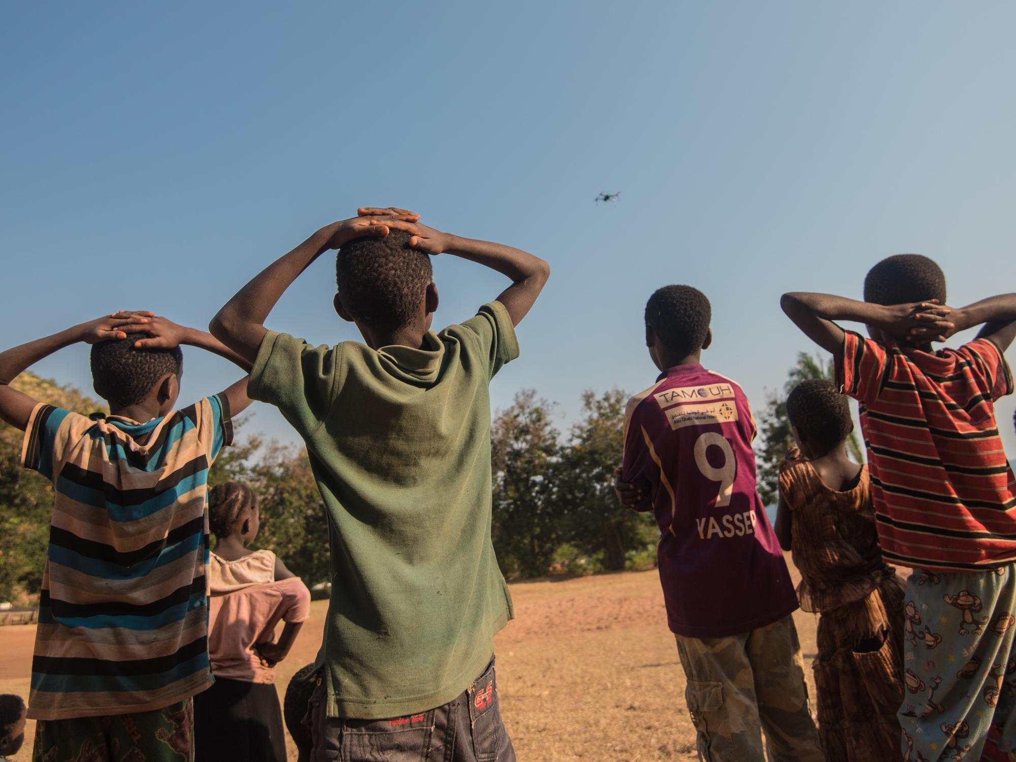 kids watch drone in flight