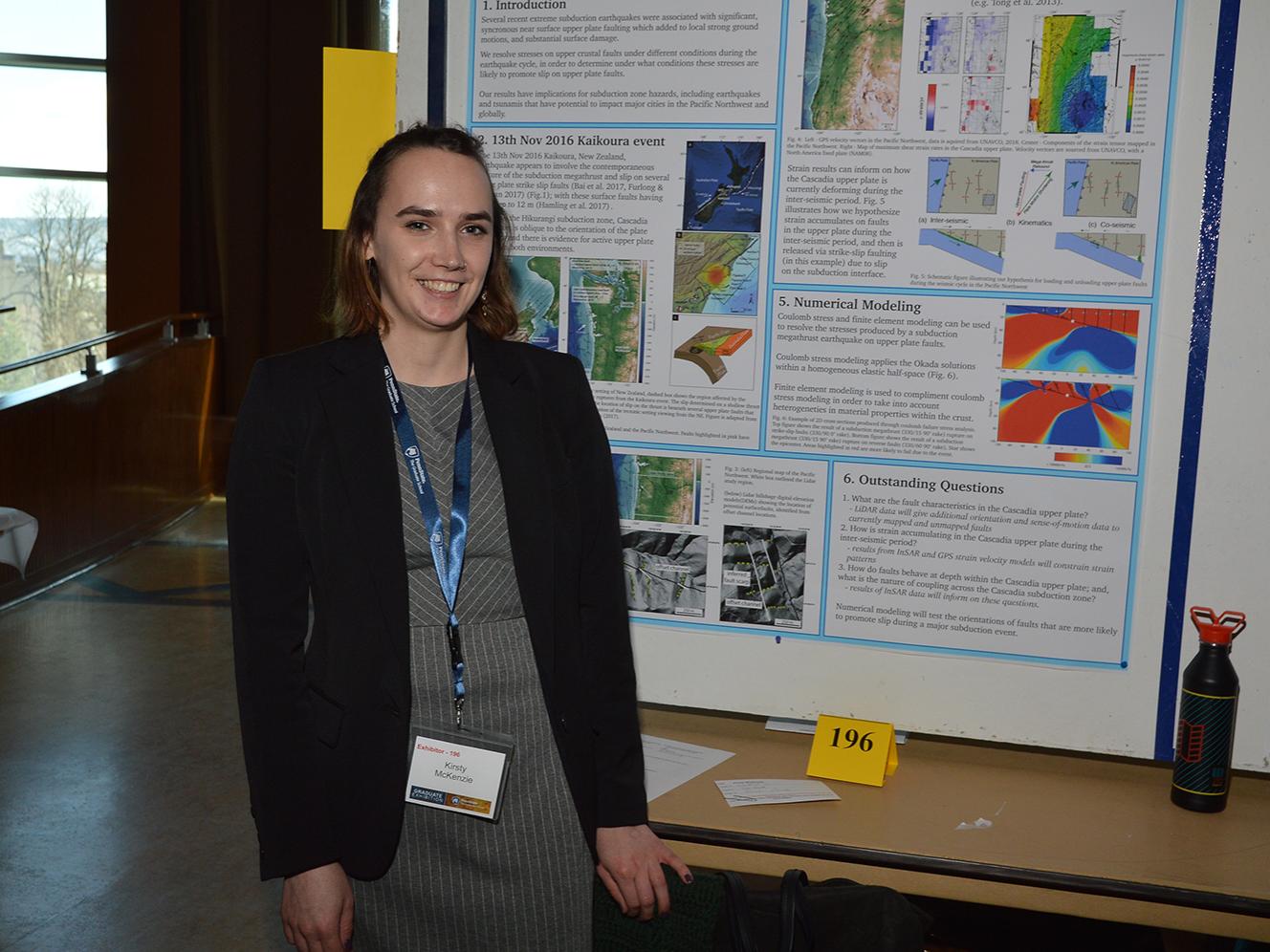 Kirsty McKenzie, geosciences graduate student, stands next to her research poster