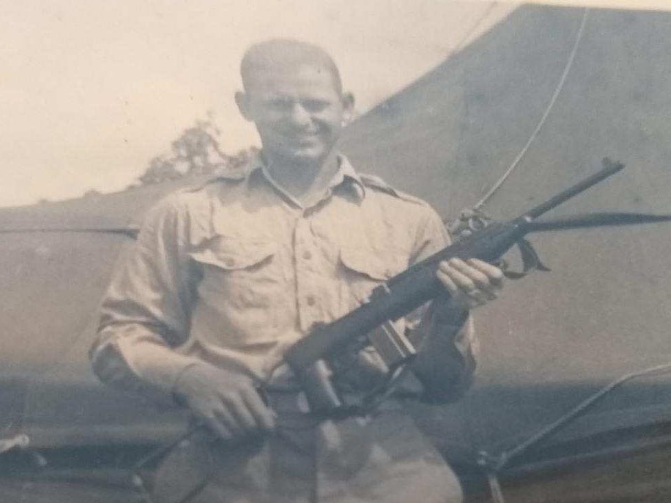 World War II veteran holding a gun