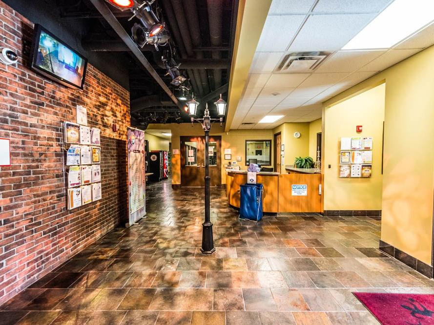 Hallway inside a recreational facility with a red brick wall