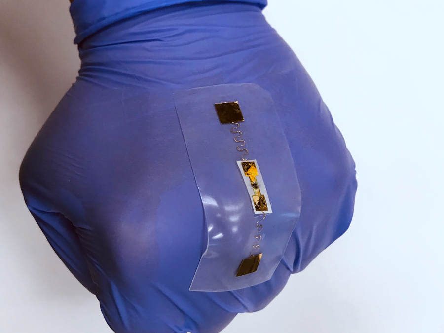 gloved hand wearing a flexible sensor on top