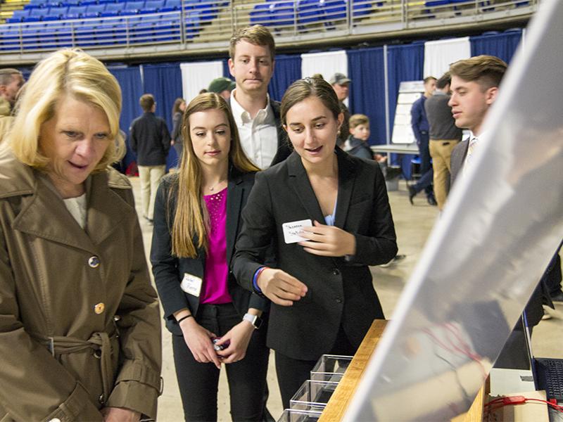 Rachel Pierce, majoring in energy leadership development and Shannon Stellato, majoring in energy engineering, center, discuss the escape room with guests.