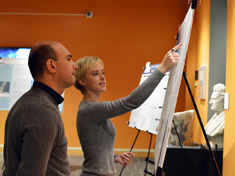 Anna Whitaker discusses her poster with Guido Cervone, associate professor in the Department of Geography and Institute for CyberScience.