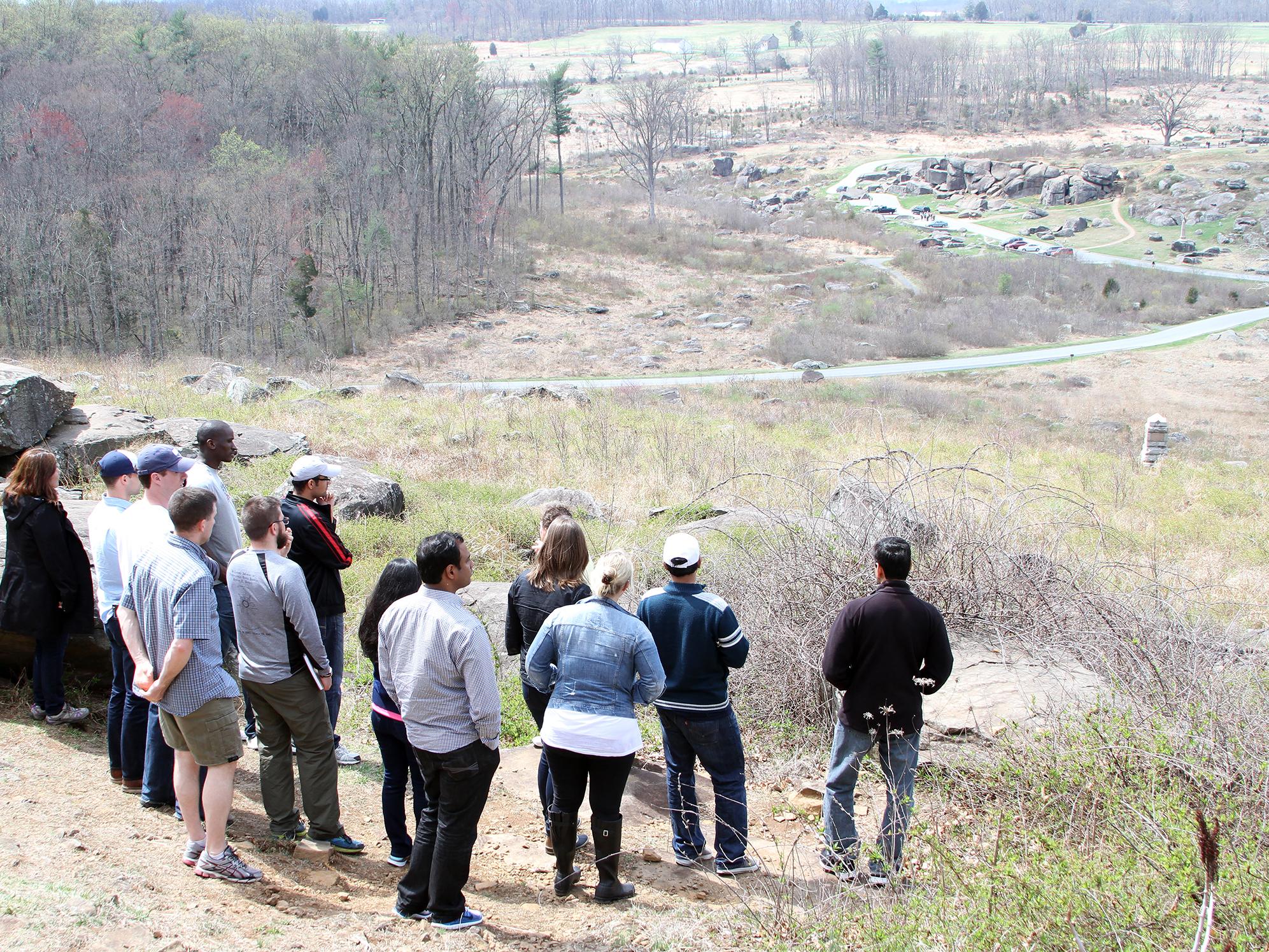 MBA students look down from Little Round Top