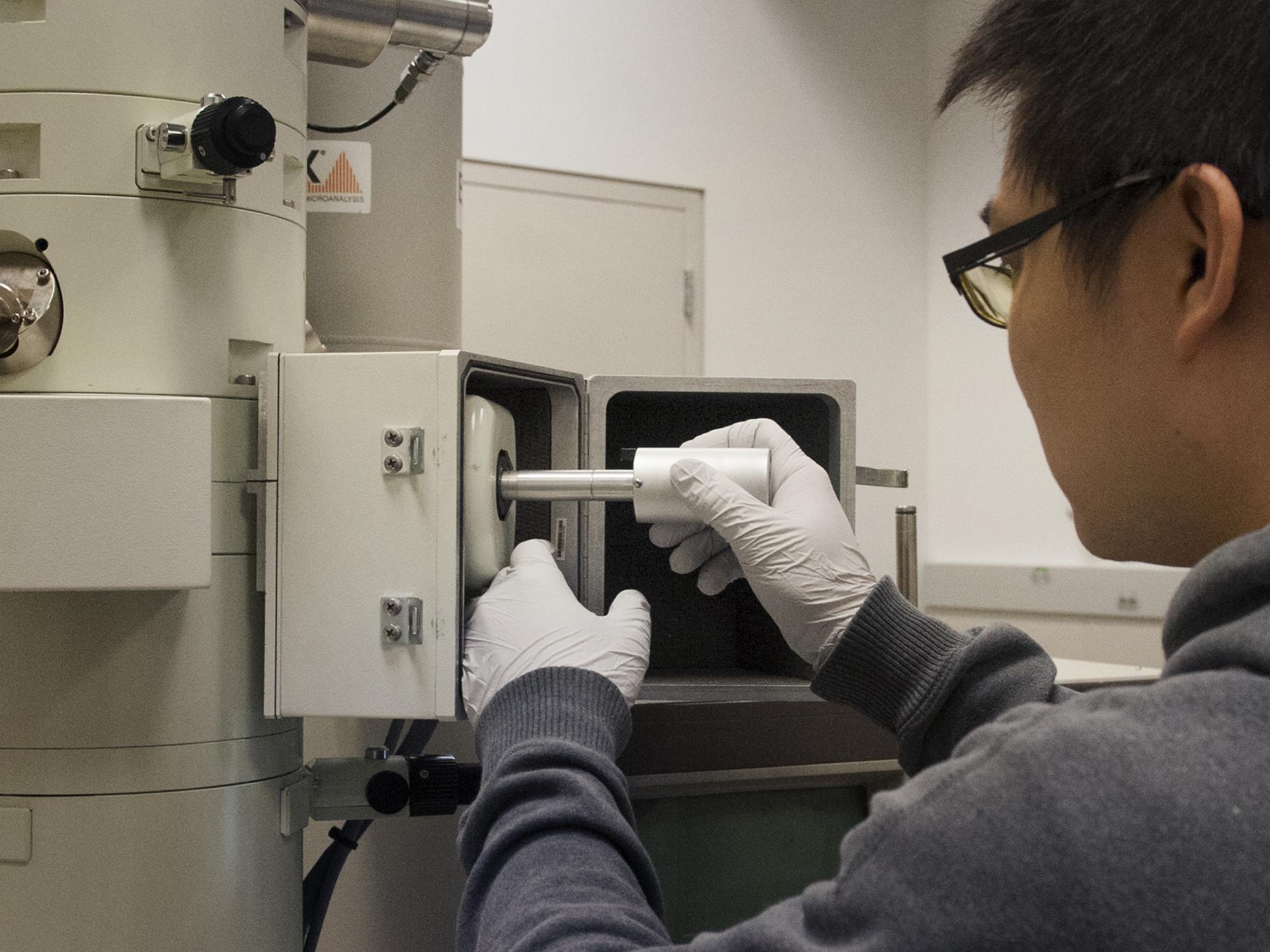 Student loads sample into electron microscope