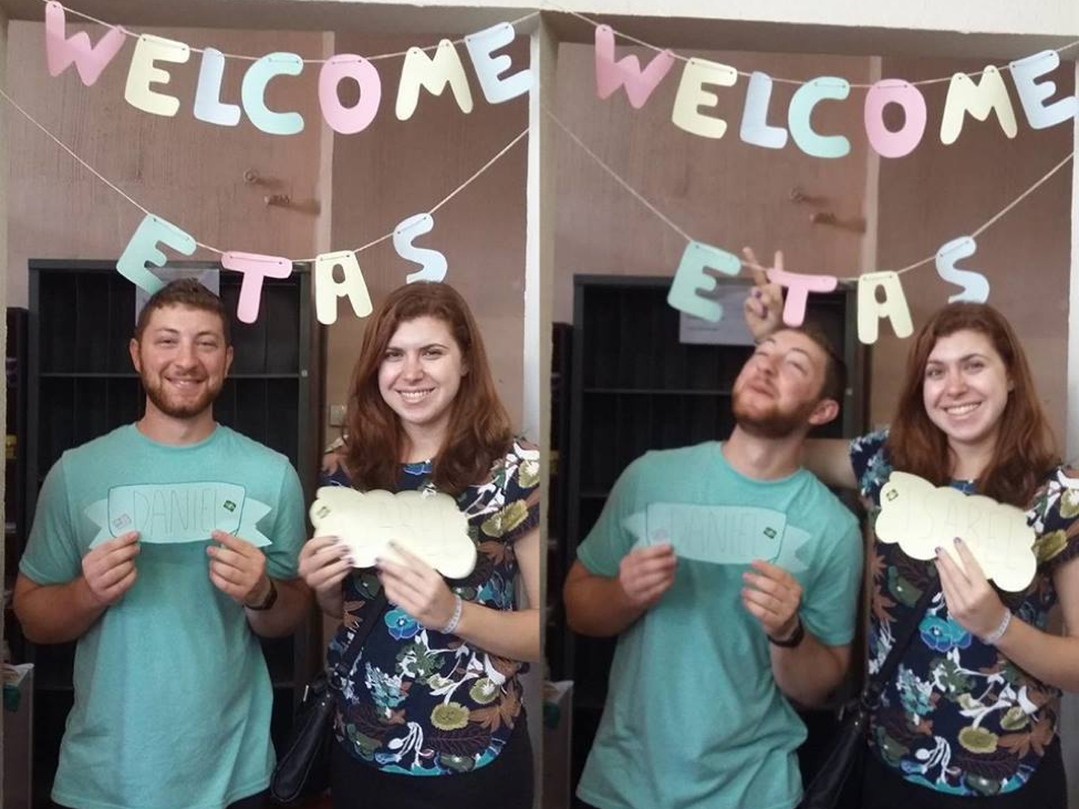 Daniel and Isabel stand under a "Welcome ETA" banner