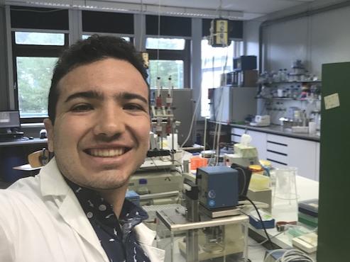 Man taking a selfie with a lab behind. 