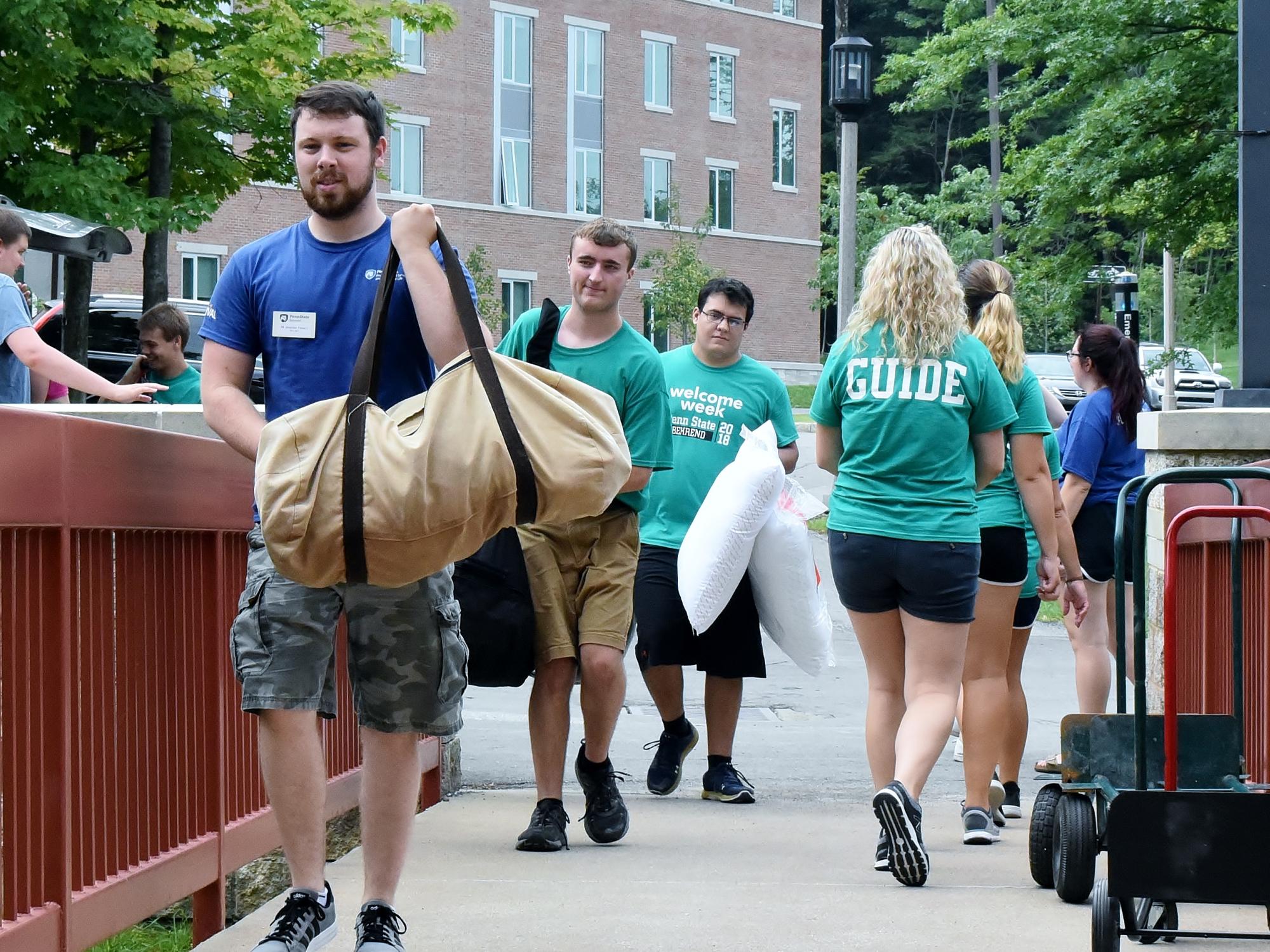 Students carry items into a residence hall at Penn State Behrend.