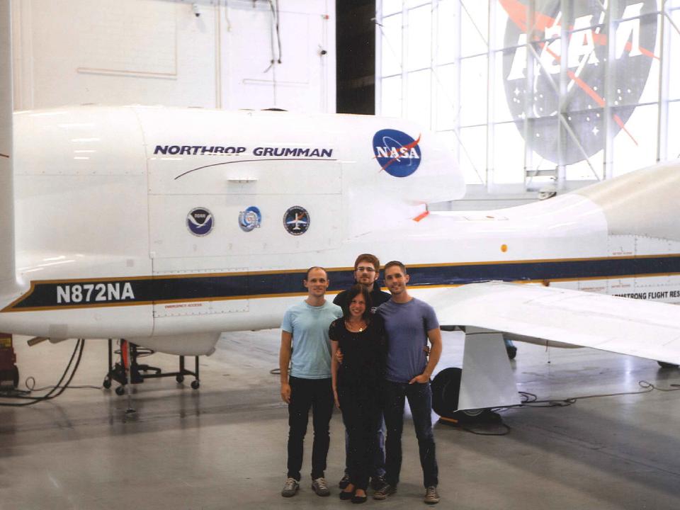 students posing next to global hawk drone