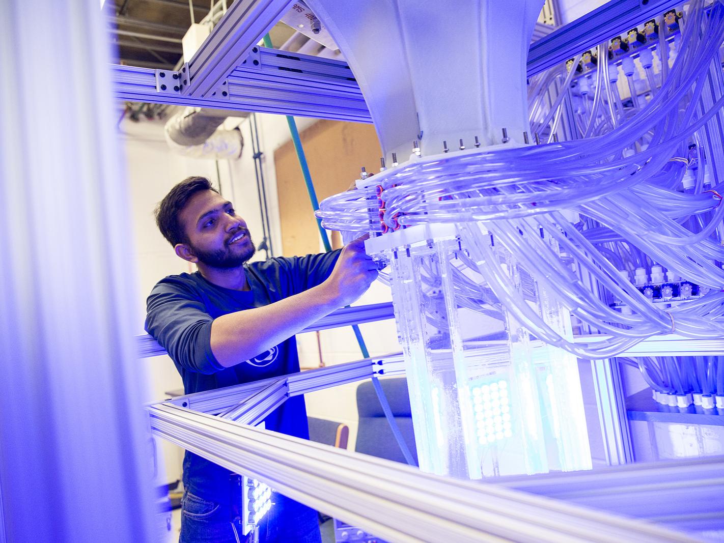 Doctoral student Ashwanth Salibindla makes an adjustment to the V-ONSET vertical water tunnel.