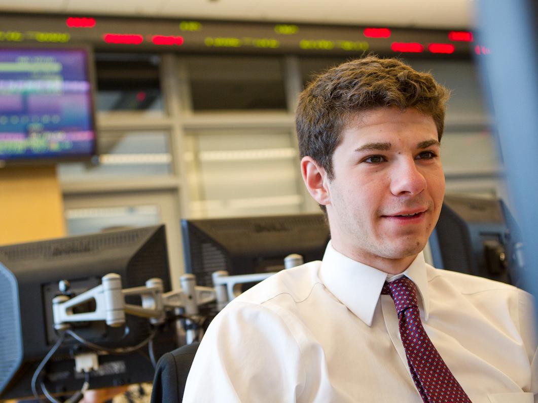 A Nittany Lion Fund student sits in front of stock ticker.