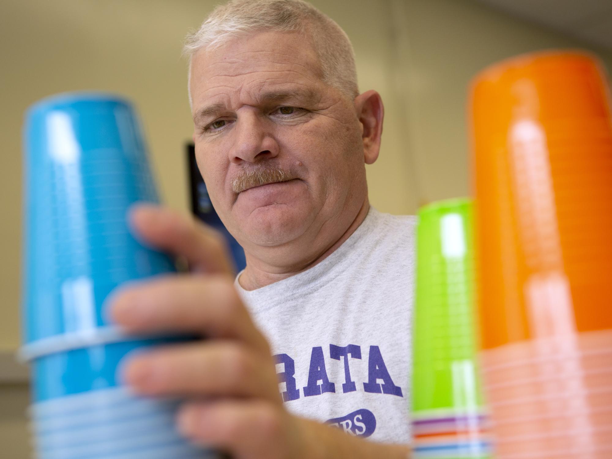 man places plastic cups in stacks