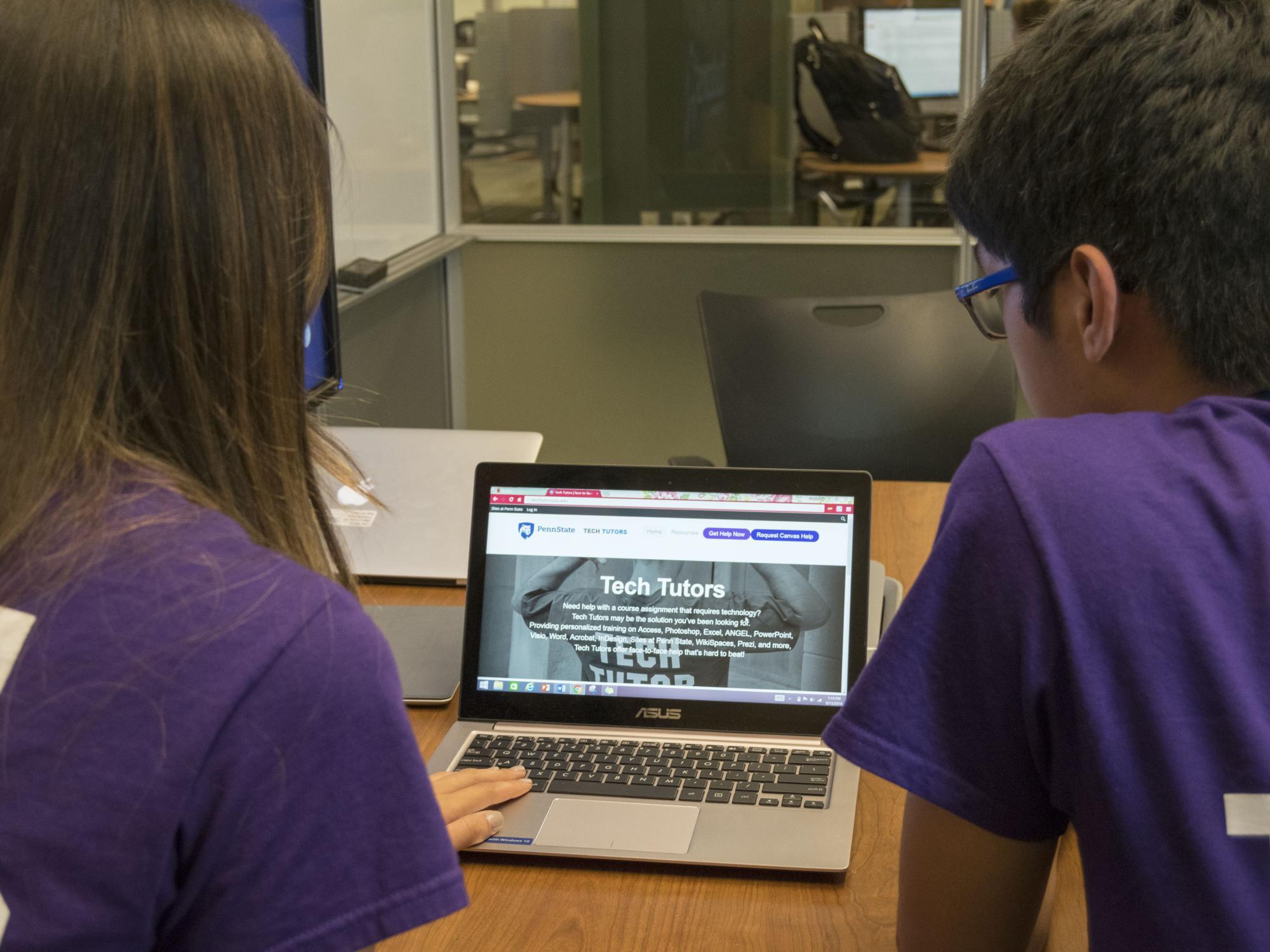 An over-the-shoulder shot of two students looking at the Tech Tutors website
