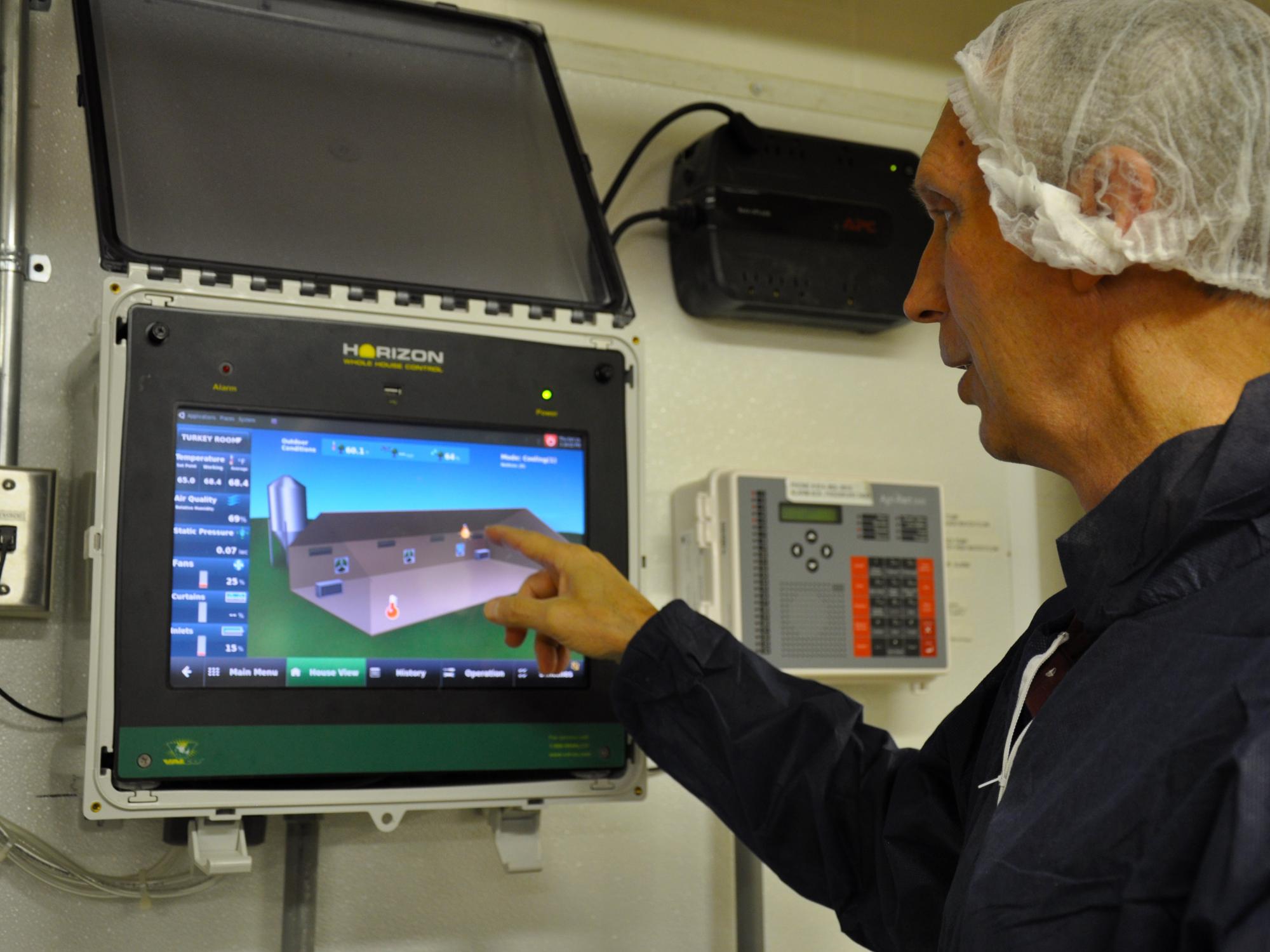 Mike Hulet using the environment control panel to make adjustments to the temperature in the turkey houses.