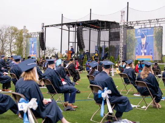 Graduates sit at an outdoor commencement ceremony at Penn State Behrend