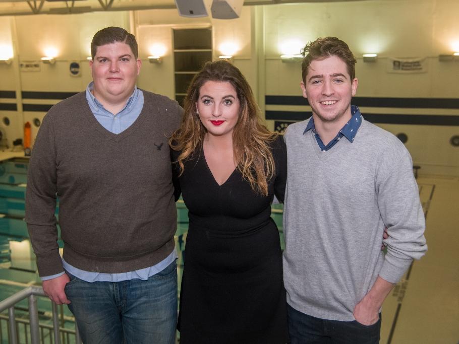 Three Penn State Behrend swimmers pose by the pool deck.