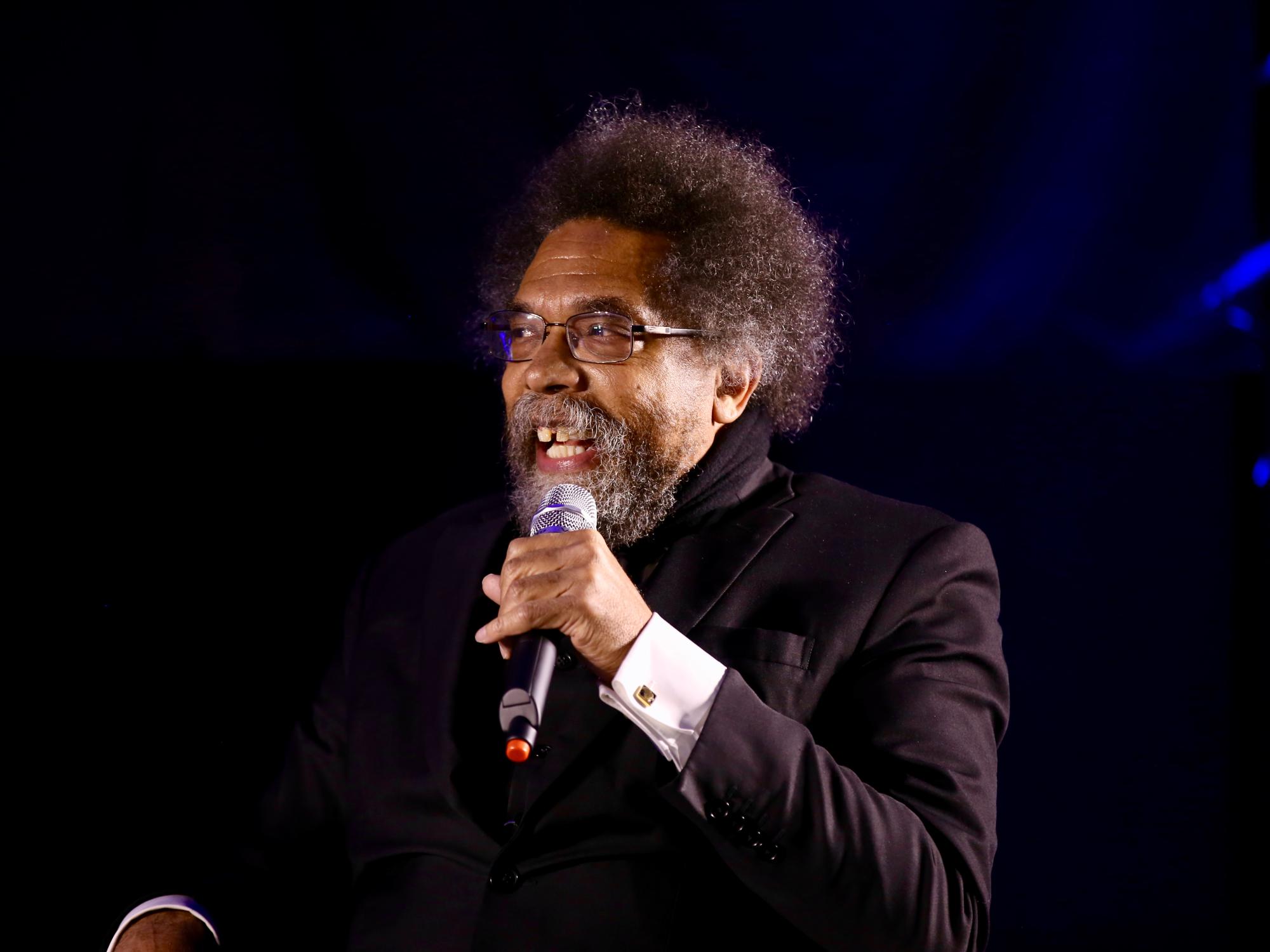 man holding microphone sitting on stage