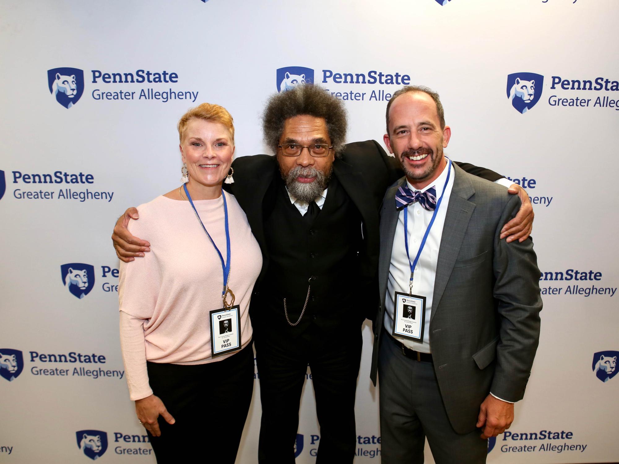 two men and a woman smiling at the camera