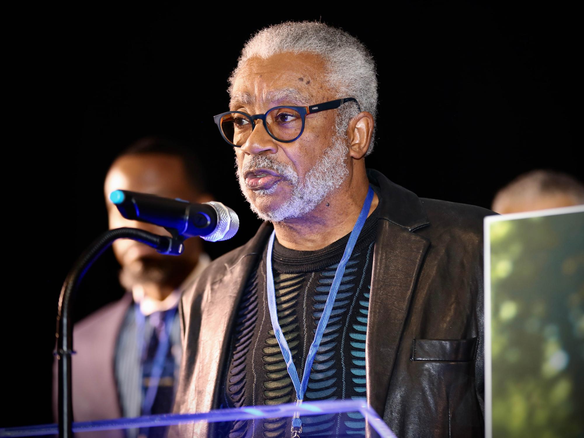 man speaking into microphone at podium