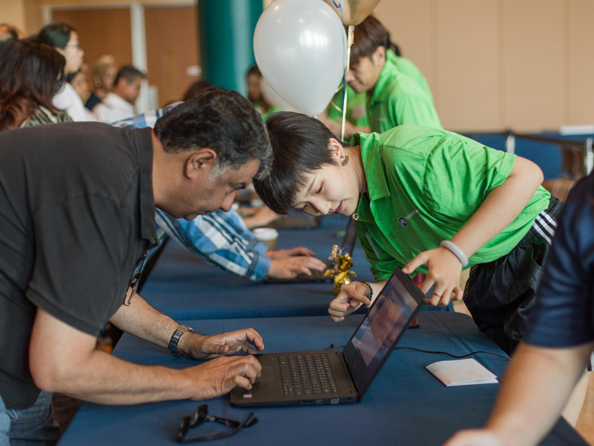 An ISO orientation leader assists a parent on a computer