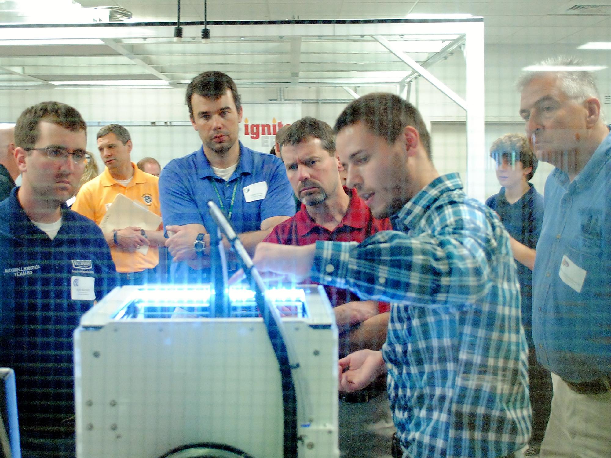 A person demonstrates a 3-D printer at the Innovation Commons