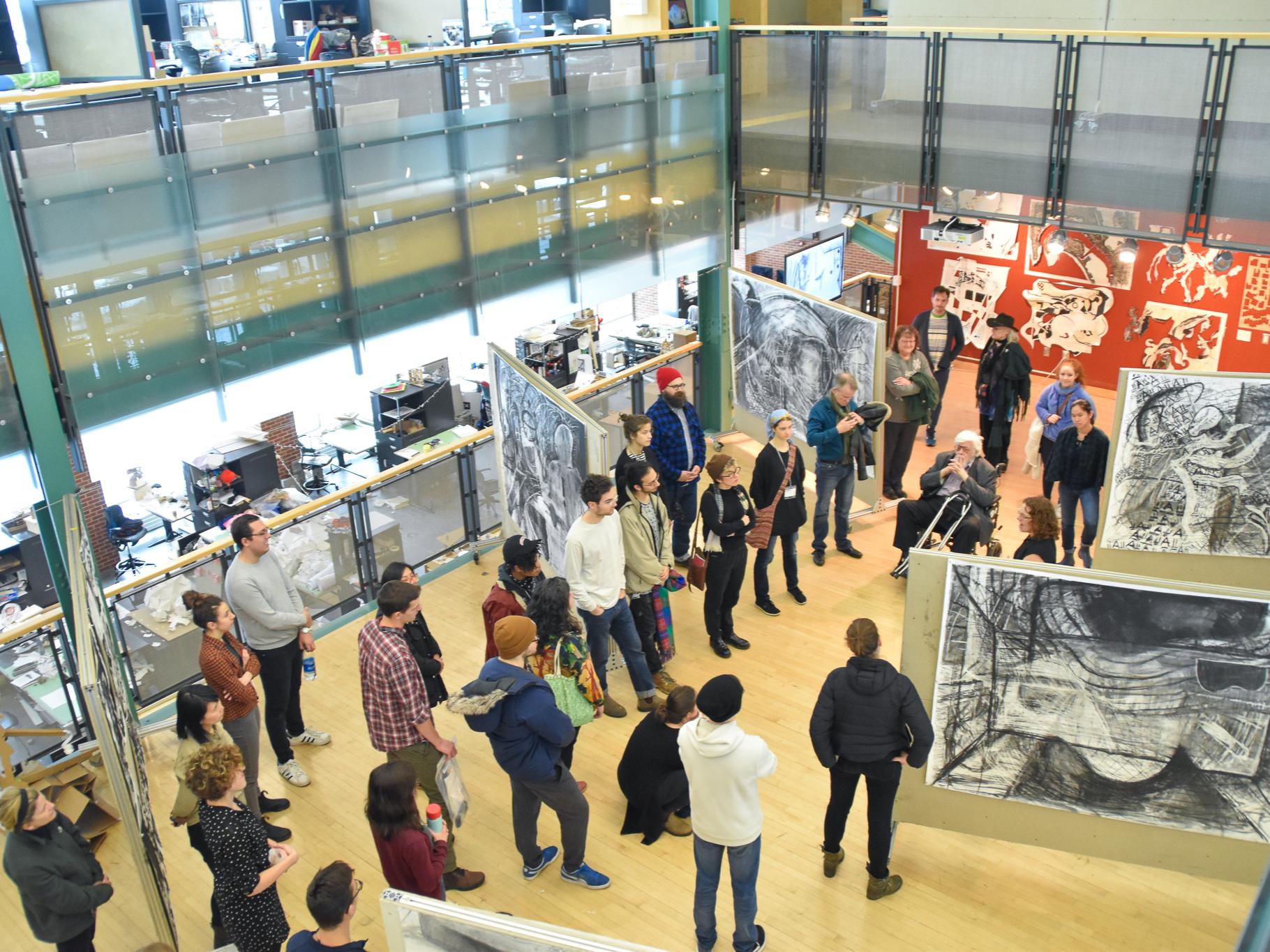 Braasch surrounded by participants in the Robert Reed Drawing Workshops at Penn State during an exhibition of work done.