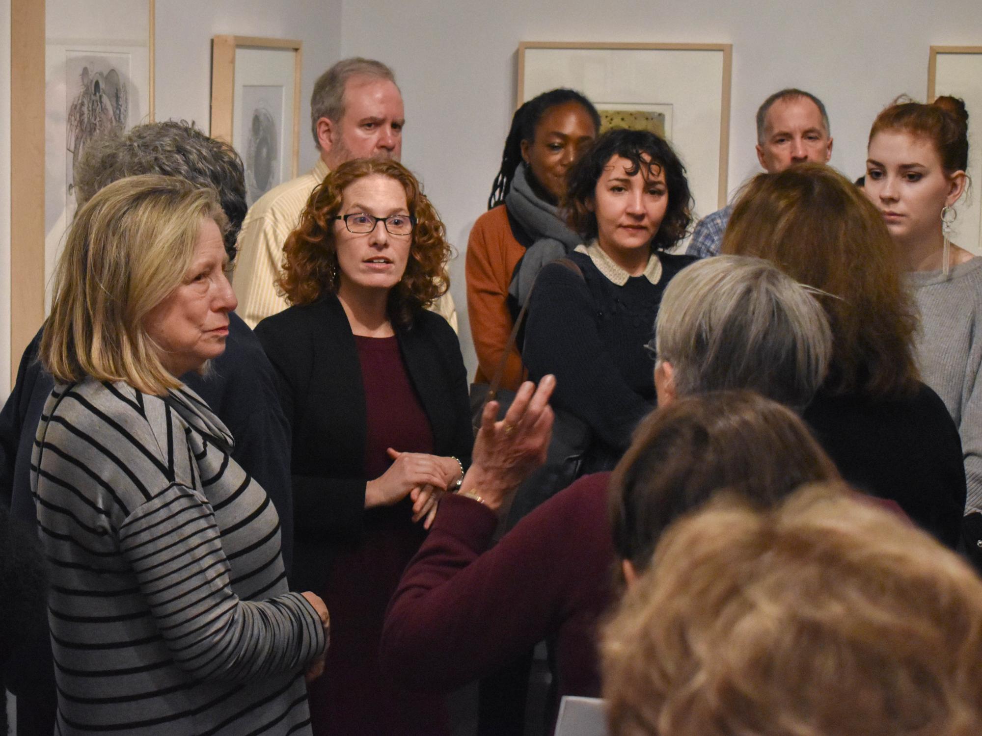 Cathy Braasch stands in the center of a group visitors to the Palmer Museum gallery talk.