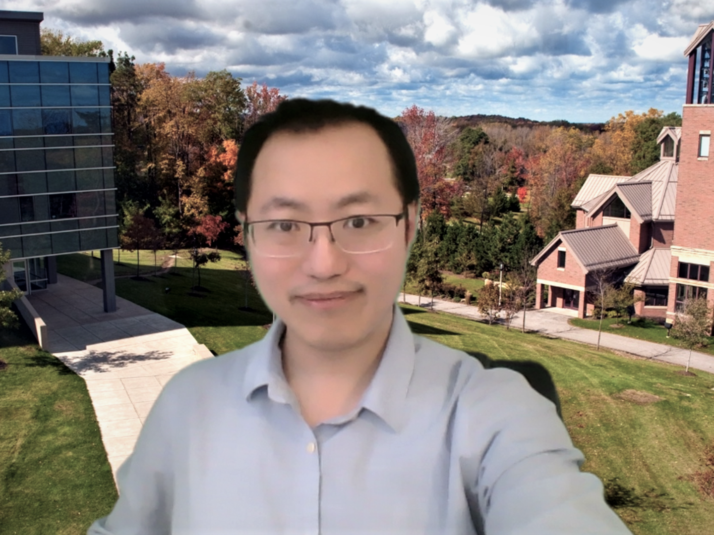 Richard Zhao, an assistant professor at Penn State Behrend, uses a custom backdrop of the Behrend campus during a class on Zoom.