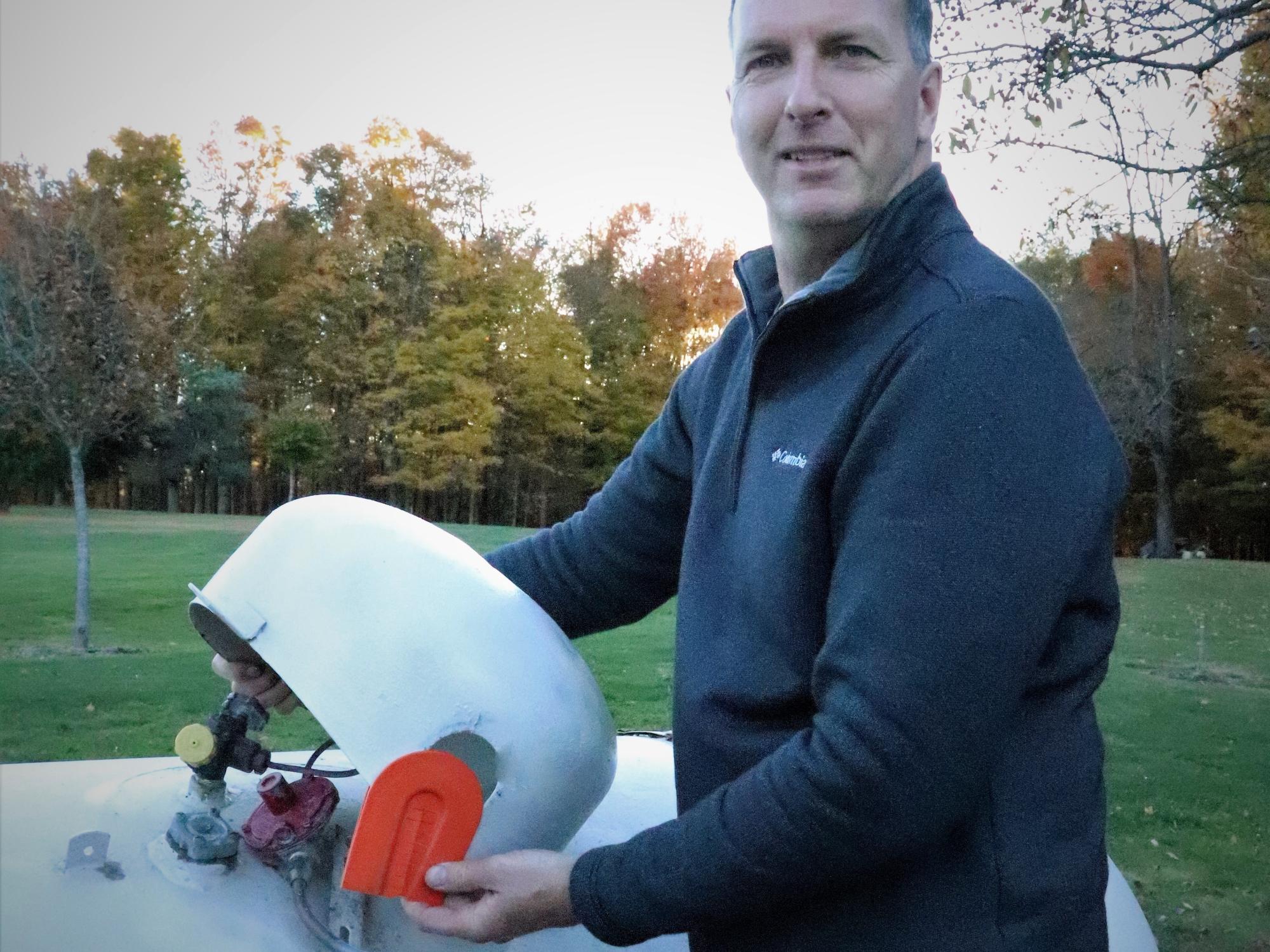 Ron Forbes poses with the ProDomeSeal, which he designed to prevent birds from nesting on propane tanks.