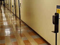 Multiple hand sanitizer pump stations located next to doors into rooms