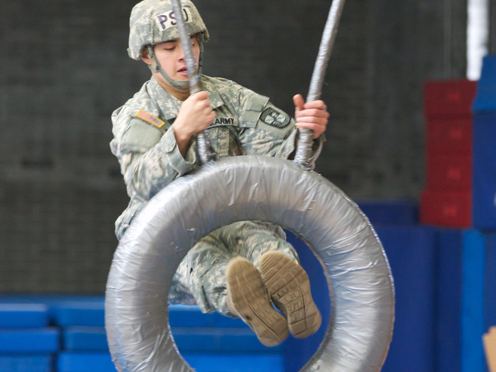 Johnathan Graham launches himself through a tire on the obstacle course