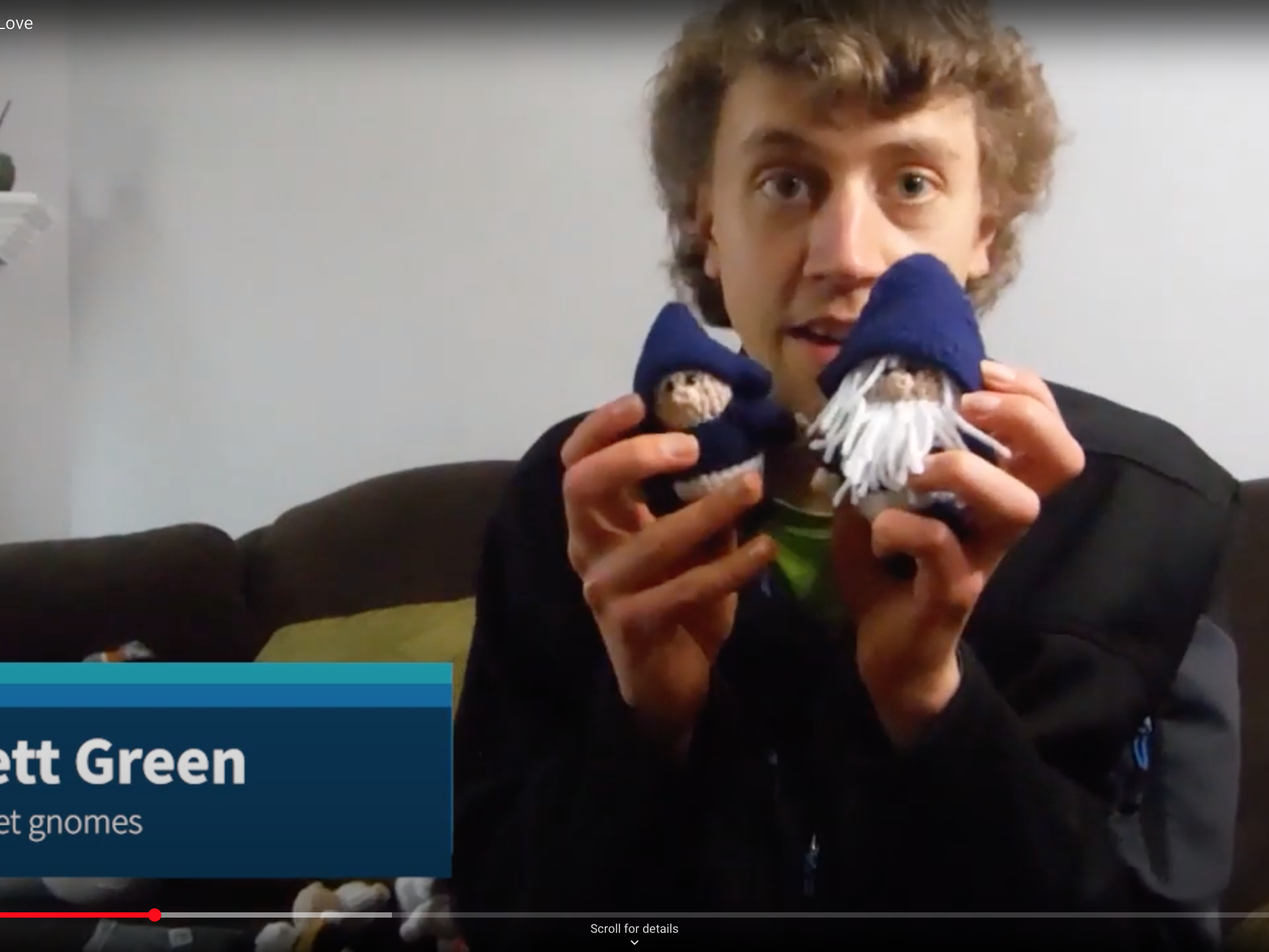 Student holding up two crochet gnomes