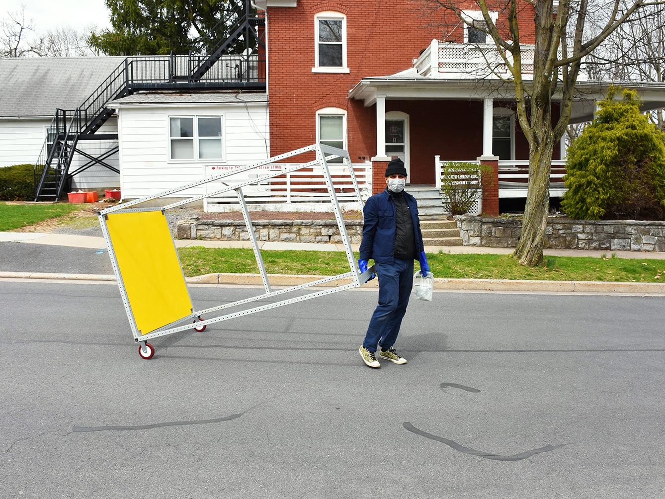 Marcus Shaffer wheels the completed frame through the streets of downtown State College to drop it off for Jamie Heilman. 