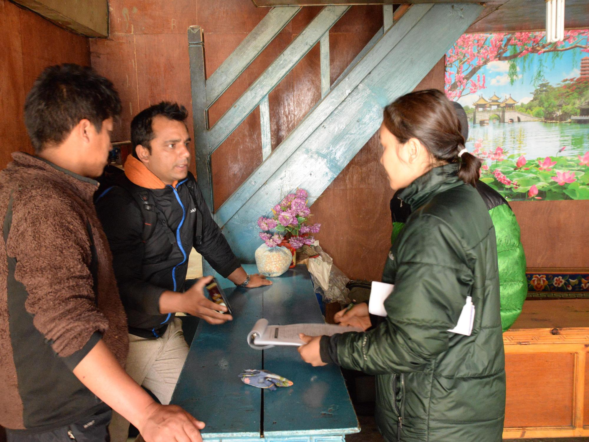 A woman and two men work to assess damaged homes.
