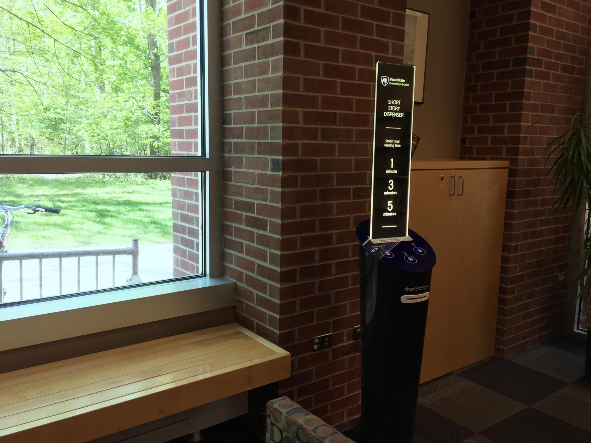 blue short story dispenser on far wall to the right of large windows of architecture and landscape architecture library at Penn State