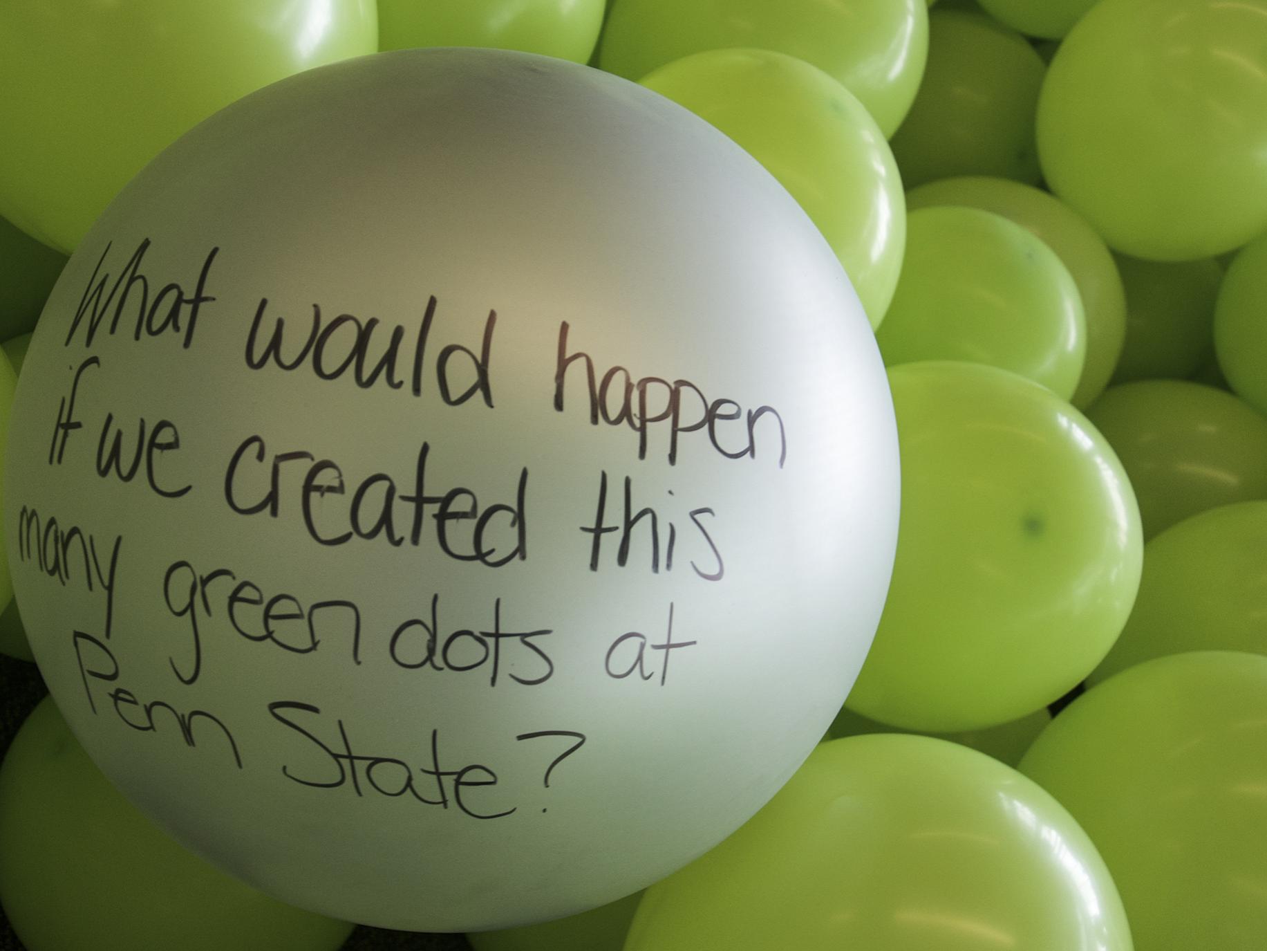 A balloon with the message "What would happen if we created this many green dots at Penn State?"