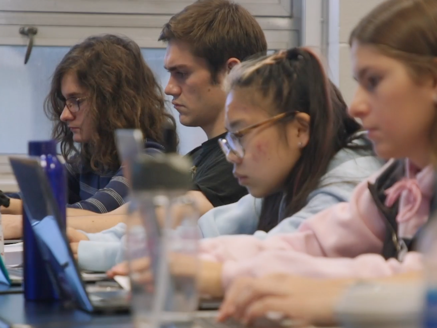 Photo of students writing on laptops