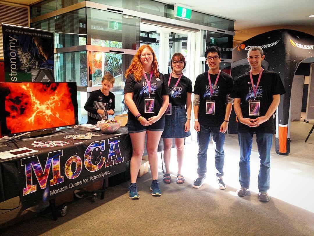Monash Centre for Astrophysics Team poses in front of their display table