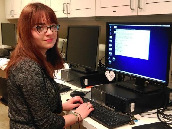 Andrea Sylvia Biscoveanu stands at computer