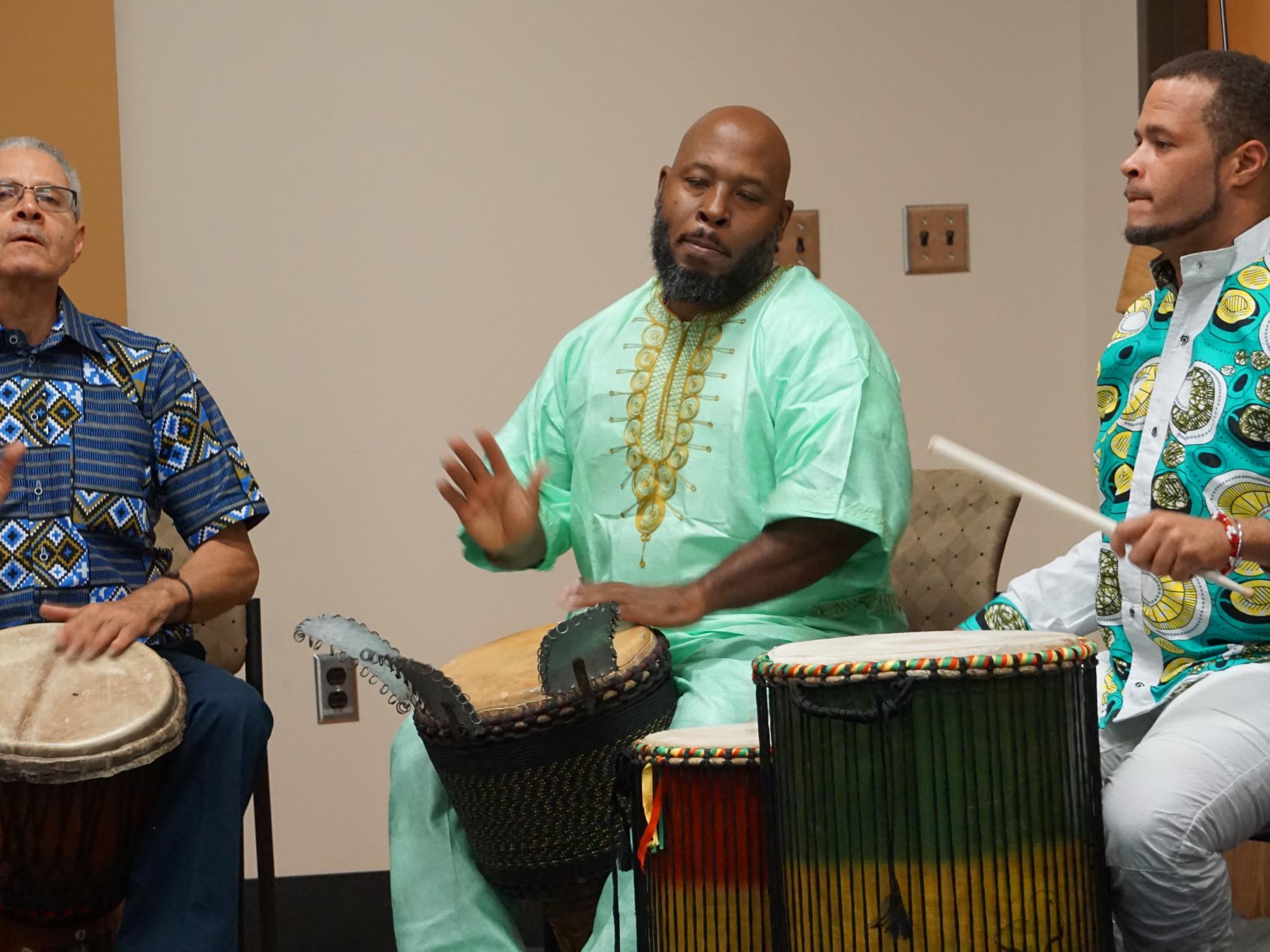 Three men playing African drums 