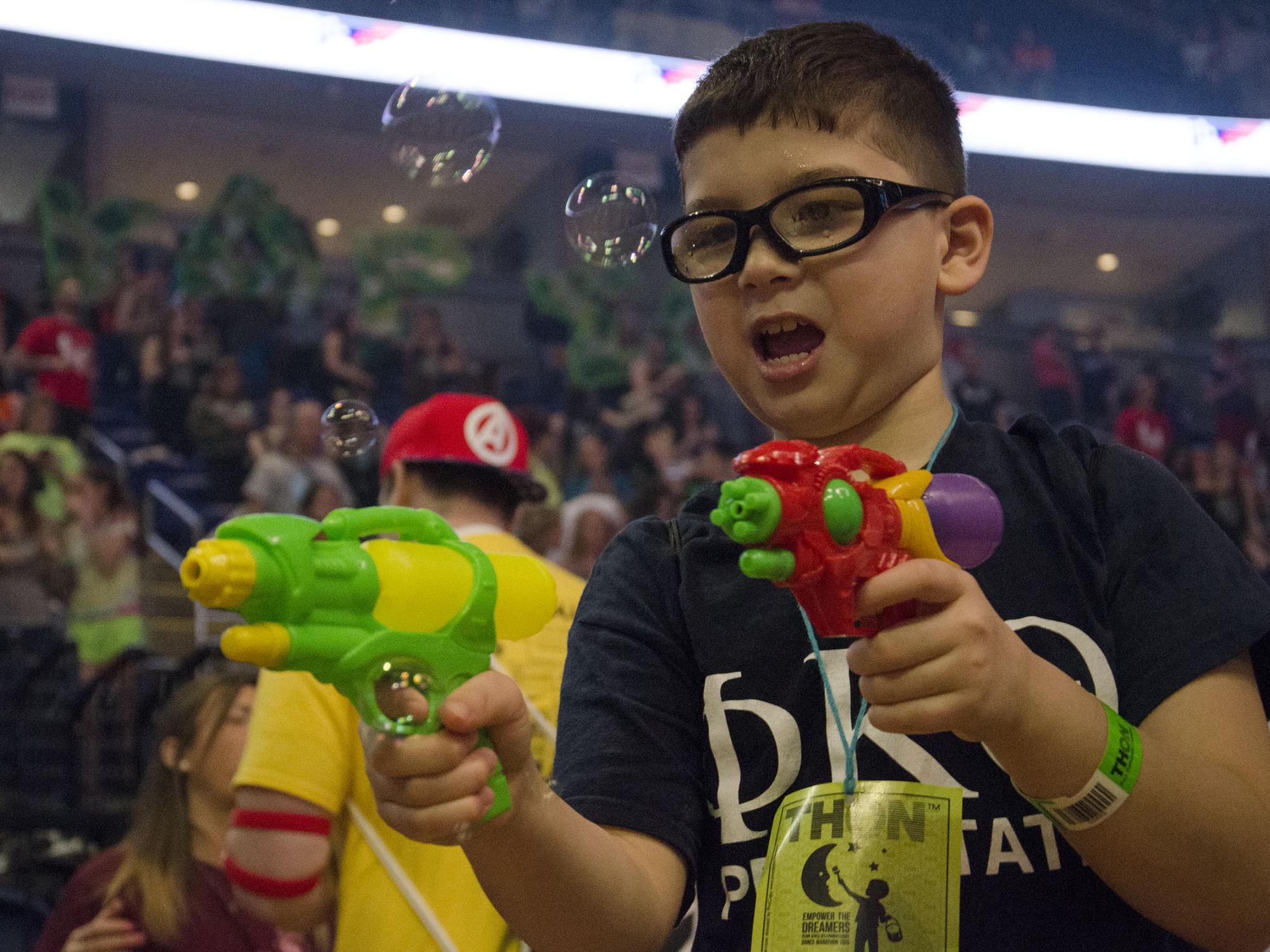 A THON child with squirt guns 