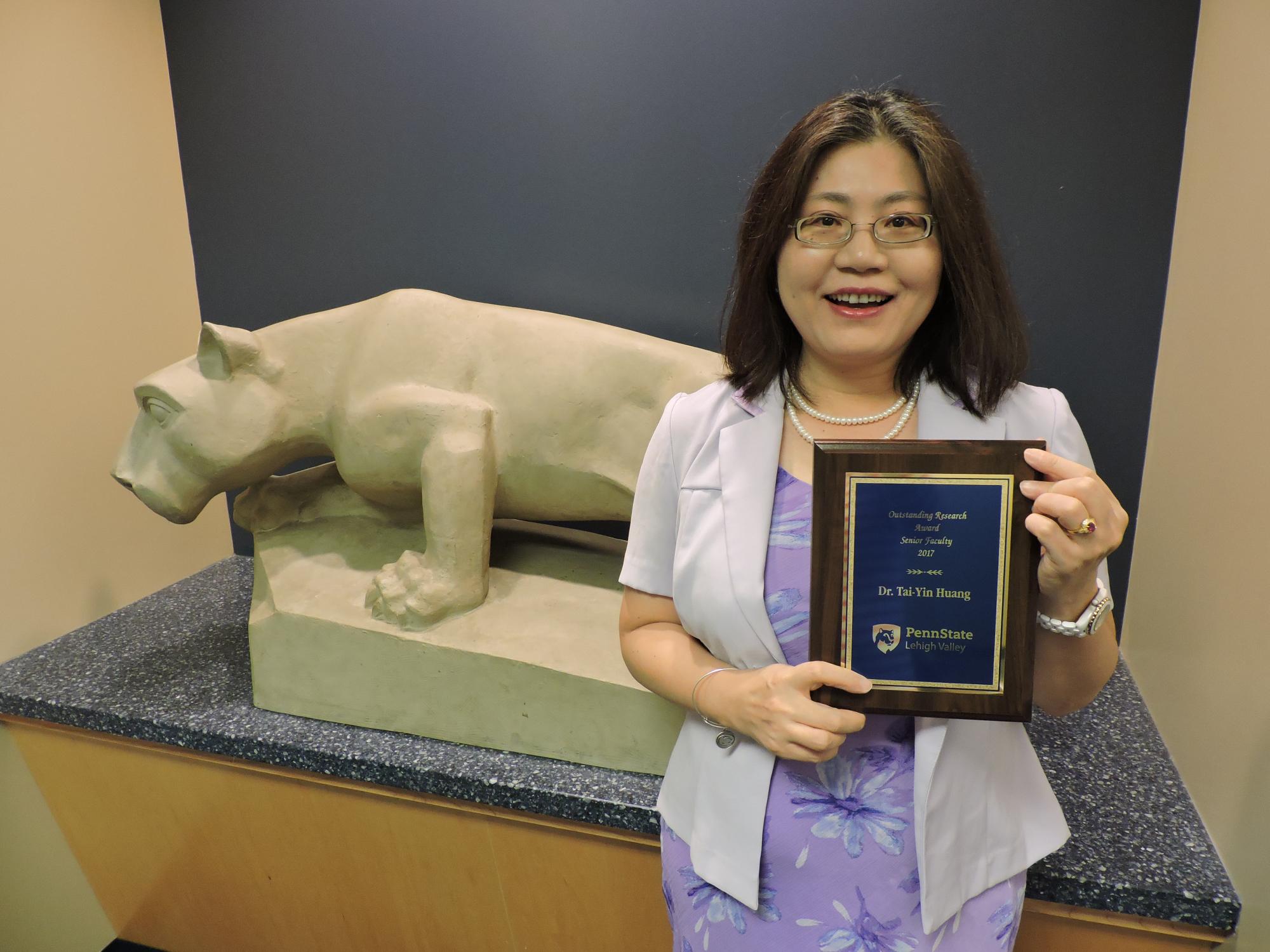woman stands with her award