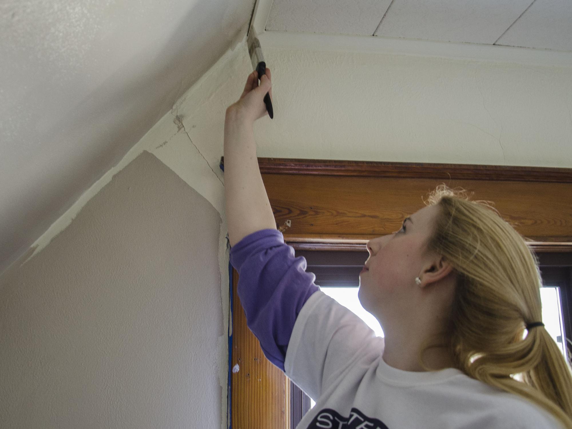 A student painting a wall 