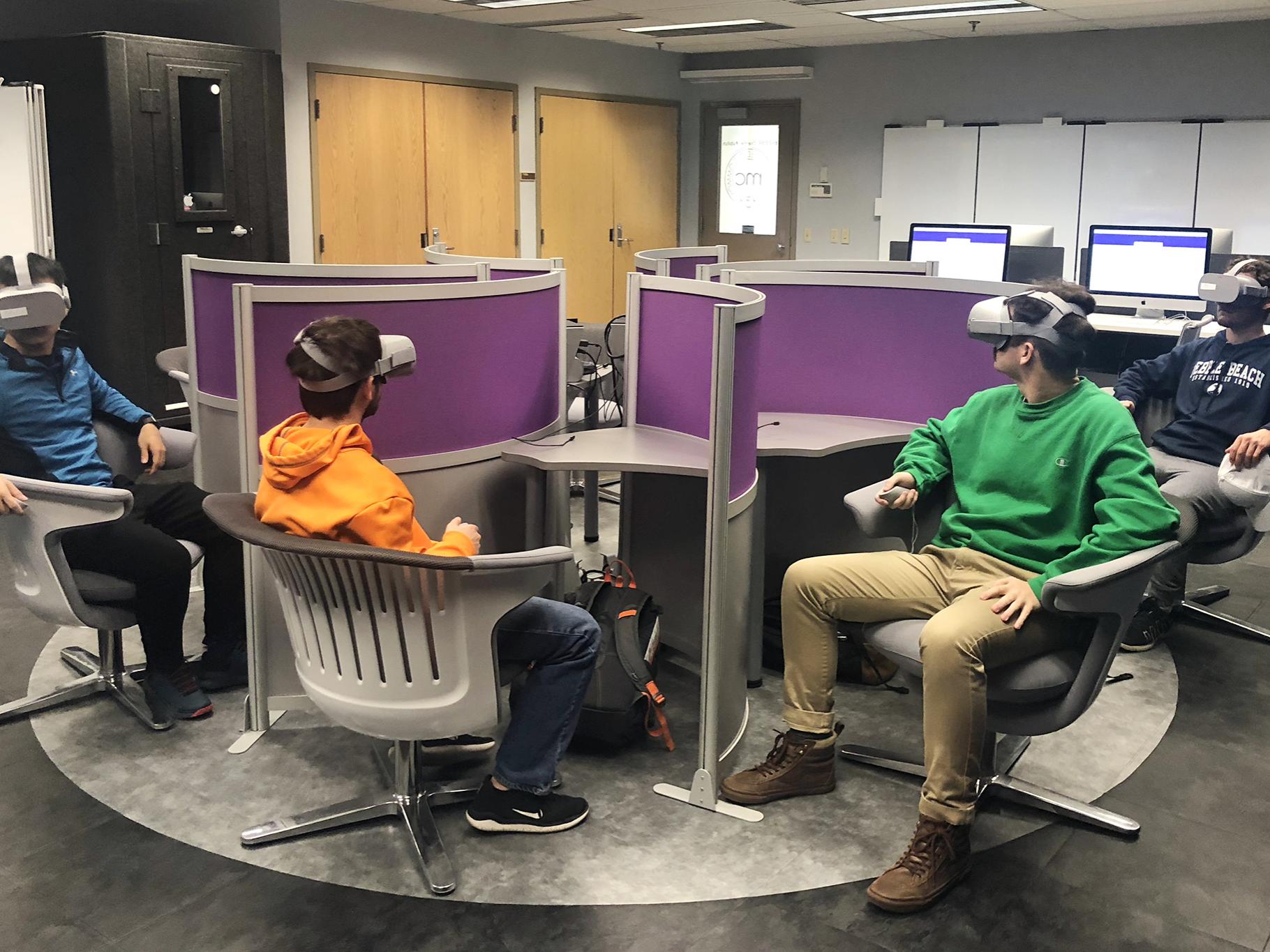 Four students travel on a virtual field trip using Oculus Go headsets at one of several virtual reality labs on campus. 