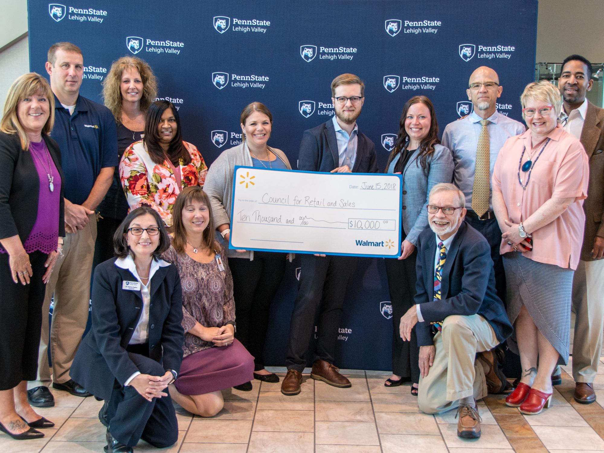 Group of employees from Penn State Lehigh Valley and Walmart standing with large signed check
